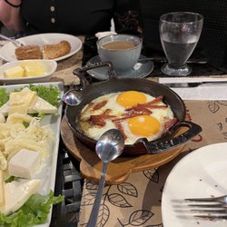 Ortaköy Fırın - Fried eggs and sausage in a cast iron skillet.