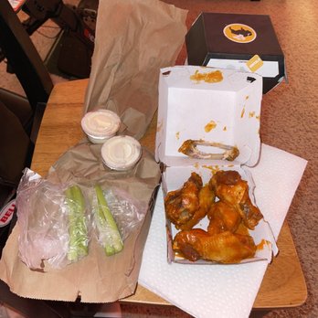 Buffalo Wild Wings - a person sitting at a table with a box of buffalo wings - American Near Me - Leesburg, Virginia Buffalo Wild Wings - a person sitting at a table with a box of buffalo wings - American Near Me - Leesburg, Virginia