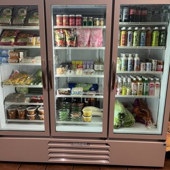 Bento-Ya - A glass-fronted refrigerator showcases Japanese grocery products, drinks, and prepared foods, including tofu, canned goods, and beverages. - Sushi Bars Near Me - Webster, New York