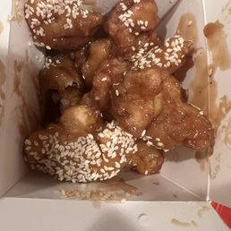 Sesame chicken with sesame on the top only one broccoli on the bottom with no sauce. Sesame chicken with sesame on the top only one broccoli on the bottom with no sauce.