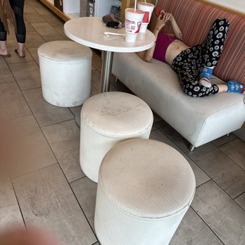 Smoothie King - a woman laying on a couch in a fast food restaurant - Juice Bars & Smoothies Near Me - Gainesville, Florida