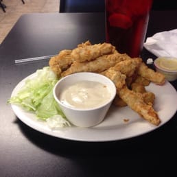 a plate of deep fried chicken strips and a bowl of dipping sauce
