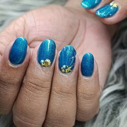 Nails V&V Sucursal Calle 66 - Mermaidcore / Ocean Aesthetic. Presenta una uña con relieve tipo "concha" y aplicaciones de joyería (dijes dorados de conchas, estrella