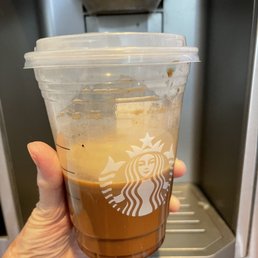 a hand holding a cup of iced coffee a hand holding a cup of iced coffee