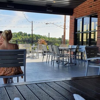 University Roadhouse - a woman sitting on a bench - American Near Me - Kalamazoo, Michigan