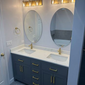 Iris Renovations - Double vanity remodel with gold fixtures, marble countertop, and custom gray cabinetry - Crystal Lake bathroom project. - General Contractors Near Me Iris Renovations - Double vanity remodel with gold fixtures, marble countertop, and custom gray cabinetry - Crystal Lake bathroom project. - General Contractors Near Me