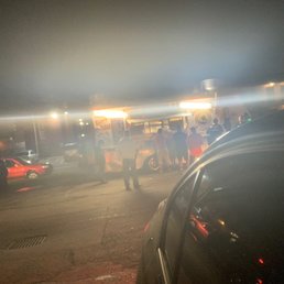 a group of people standing in a parking lot a group of people standing in a parking lot