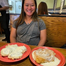 a woman sitting at a table with two plates of food