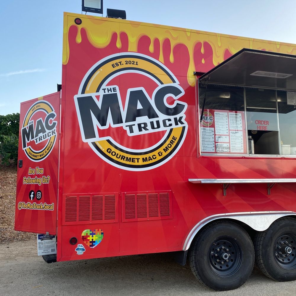 a red food truck parked in a parking lot a red food truck parked in a parking lot