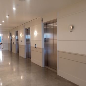 Convene - A corridor featuring several stainless steel elevator doors, wall-mounted lights, and a polished floor, likely in a commercial or office building. - Venues & Event Spaces Near Me - Chicago, Illinois