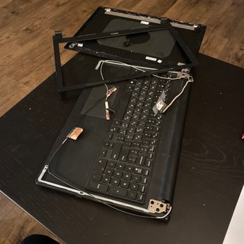 TechCare Computers - Computer after service - A laptop with its screen removed and broken parts scattered on a black table, with wires and connectors visible. - IT Services & Computer Repair Near Me - Los Angeles, California