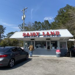 a man standing in front of a dairy land a man standing in front of a dairy land