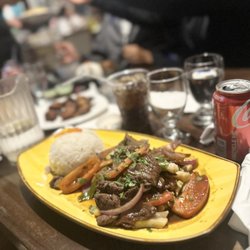 Los Andes Restaurant - Lomo Saltado, sautéed beef strips, onions, tomato on a bed of fries with a side of white rice.