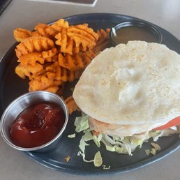 Fried chicken sandwich with bao bun and sweet potato fries