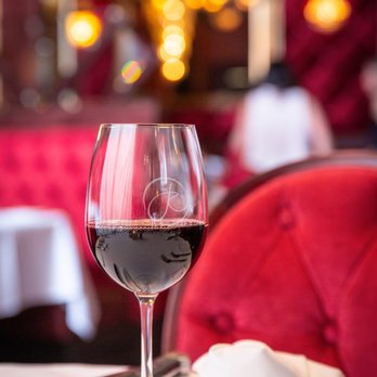 The Precinct - a glass of red wine on a table - Steakhouses Near Me - Cincinnati, Ohio