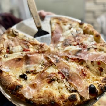 V Pizza - a person holding a pizza in their hand - Pizza Near Me - Cary, North Carolina V Pizza - a person holding a pizza in their hand - Pizza Near Me - Cary, North Carolina