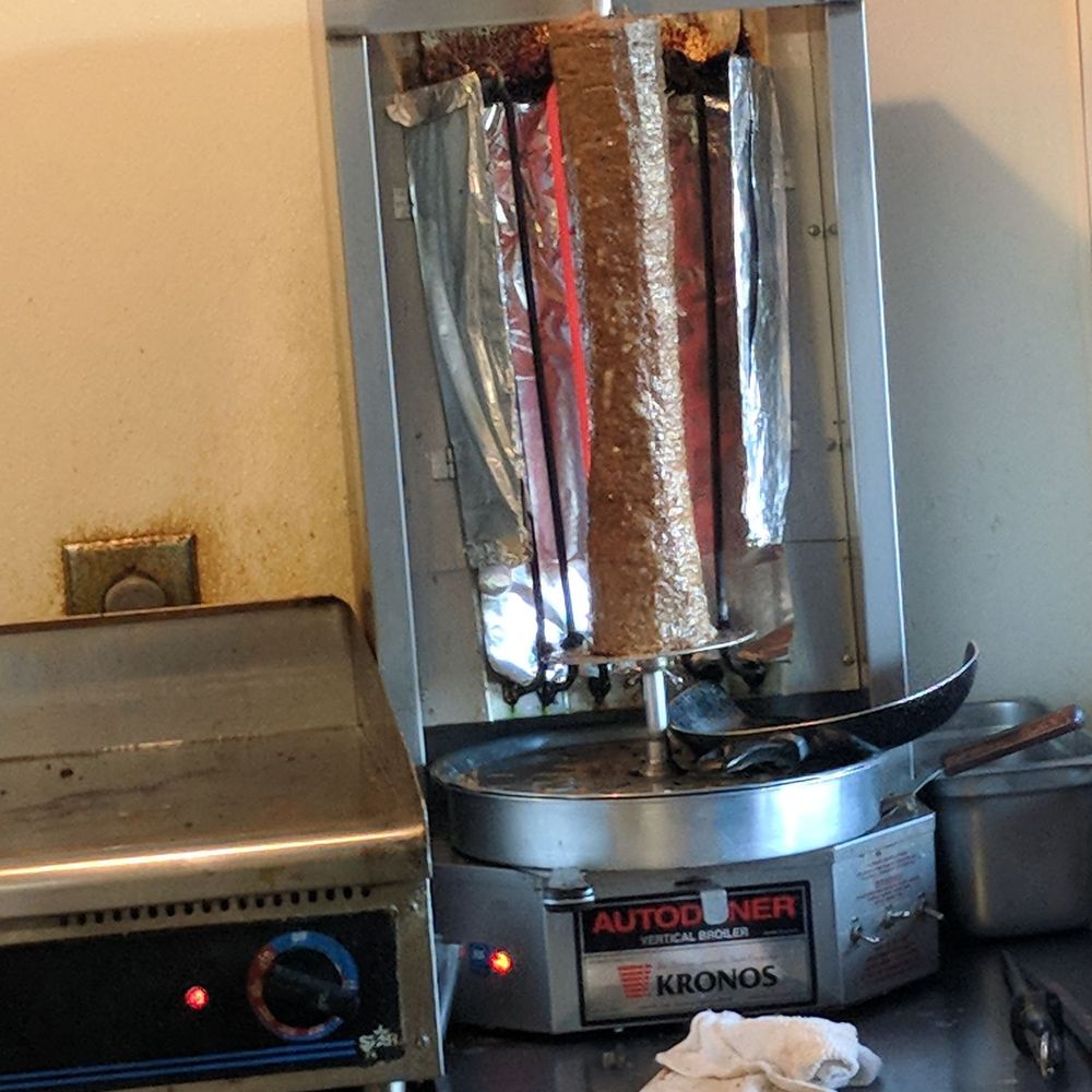 Yannis Gyros - a large meat roaster in a commercial kitchen - Greek Near Me - Springfield, Illinois Yannis Gyros - a large meat roaster in a commercial kitchen - Greek Near Me - Springfield, Illinois