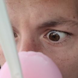 a man eating a pink ice cream