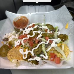 NACHOS W/ CHEESE, JALAPEÑO, SOUR CREAM, TOMATO, LETTUCE, CILANTRO, AND ONION.