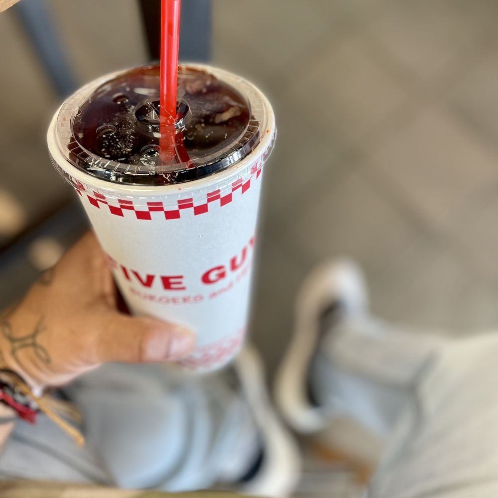 Five Guys - a person holding a cup of soda - Burgers Near Me - Jacksonville, Florida Five Guys - a person holding a cup of soda - Burgers Near Me - Jacksonville, Florida