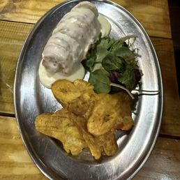 Chicken wrapped in bacon with a cheese sauce and tostones
