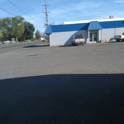 In the auto parts parking lot with the building with the blue trim roof
