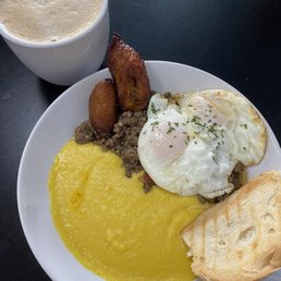 Picadillo Hash (Two fried eggs on top of picadillo(ground beef), with a side of yellow grits, small cuban toast and sweet plantains.) Picadillo Hash (Two fried eggs on top of picadillo(ground beef), with a side of yellow grits, small cuban toast and sweet plantains.)