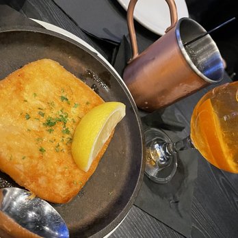 Tavern On The Point - a pan of fish with a lemon wedge - Cocktail Bars Near Me - Chicago, Illinois Tavern On The Point - a pan of fish with a lemon wedge - Cocktail Bars Near Me - Chicago, Illinois