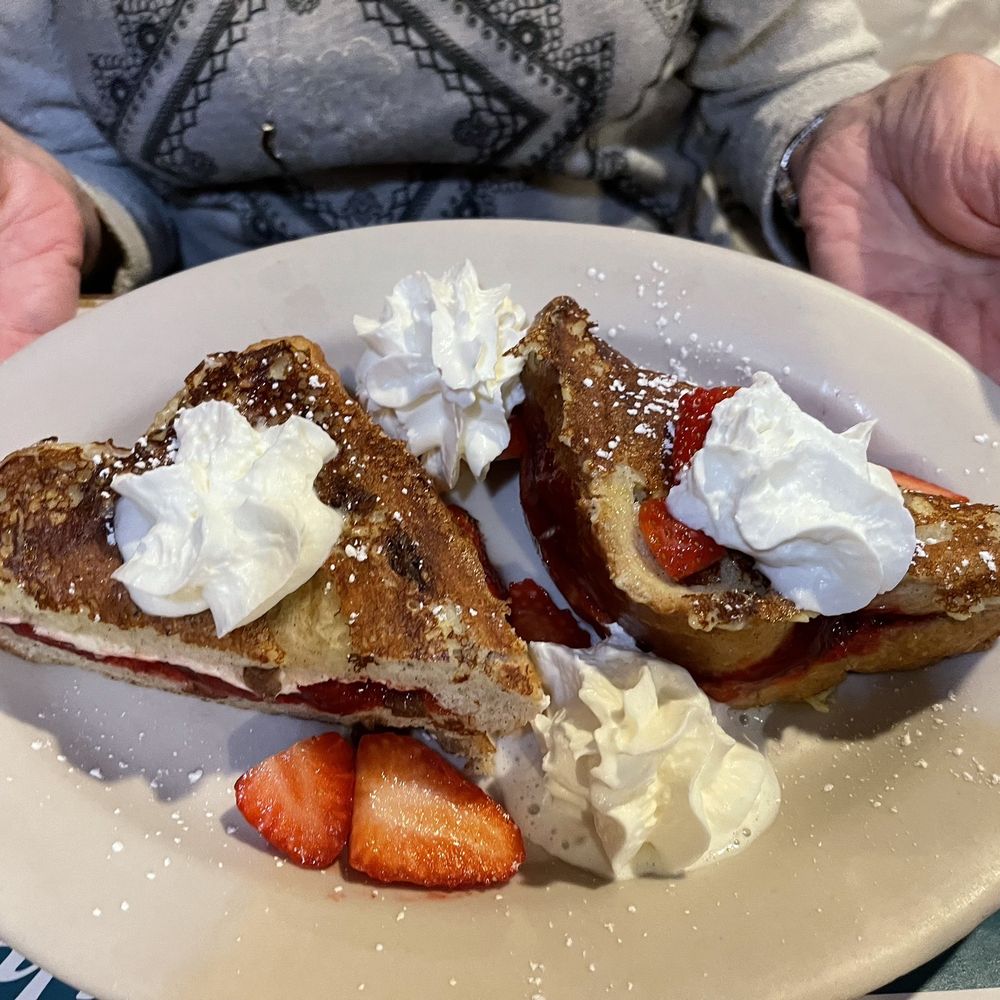 Annette is enjoying her strawberry  stuffed French toast with coffee