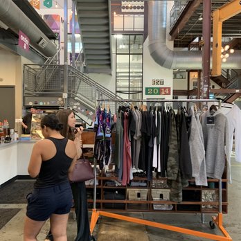 Caboose Commons - The airy space of the brewery includes tee shirts on a pole for sale, adding softer appeal to the cooler hardware. - Breweries Near Me - Fairfax, Virginia