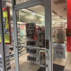 GNC - Glue residue on door from the removed store sign of scheduled hours.