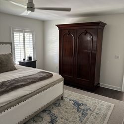Steven Postan's Antiques - Wardrobe as a focal point hiding books and decor.