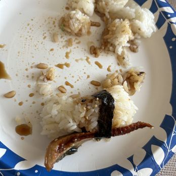 Sushi King - Eel sushi - A paper plate with remnants of sushi, including rice, eel, sesame seeds, and soy sauce, is shown. The plate has a blue and white floral border. - Sushi Bars Near Me - McHenry, Illinois