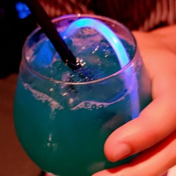 Blue Martini - a person holding a blue drink - Lounges Near Me - Miami, Florida