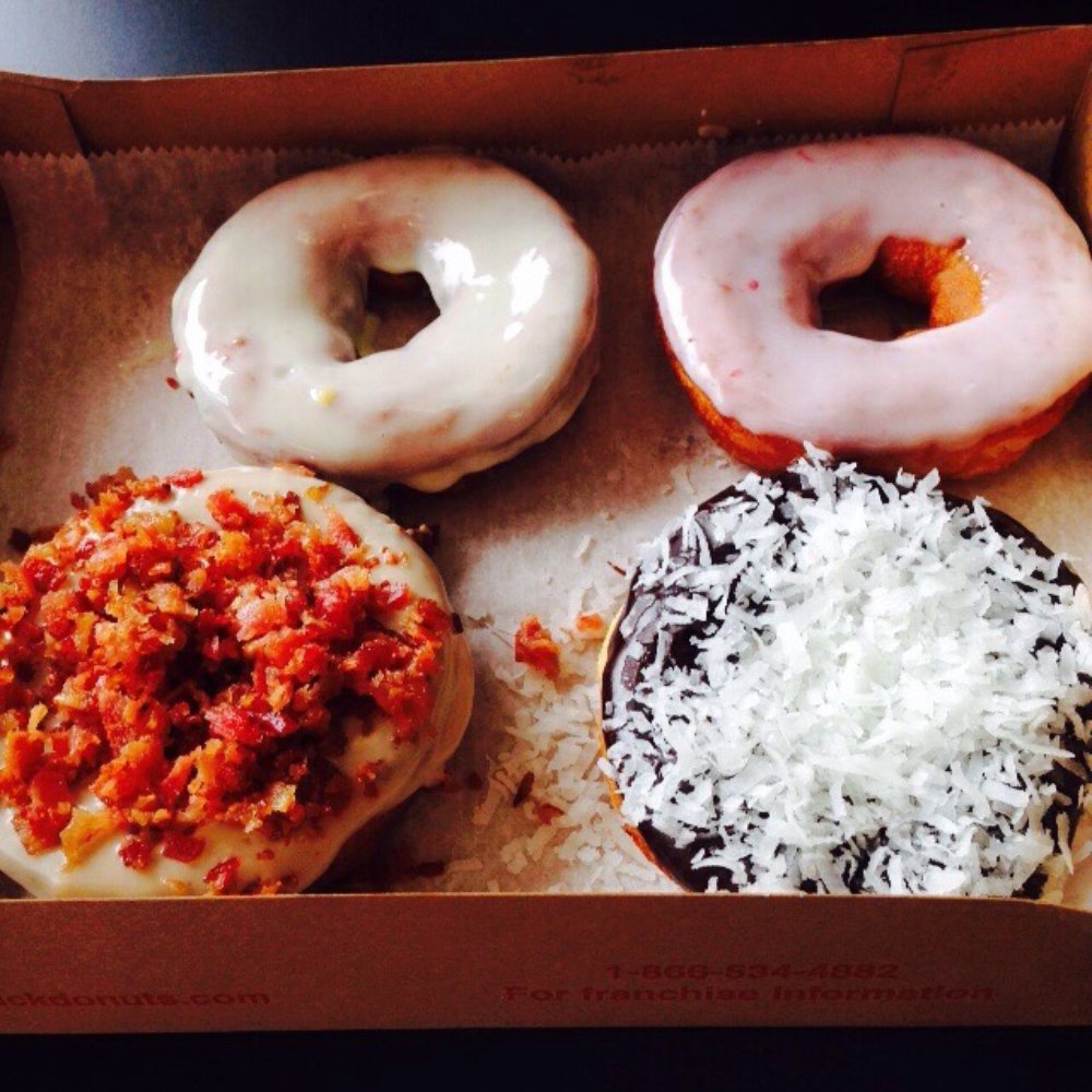 Duck Donuts - Clockwise from top left: lemon icing, strawberry icing, chocolate icing with coconut, and maple icing with bacon. - Desserts Near Me - Bristow, Virginia