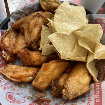 Jefferson's - Traditional Wings - A serving of fried chicken wings with potato chips on a tray, with a cup in the background, at Jefferson's in Lawrence, Kansas. - American Near Me - Lawrence, Kansas