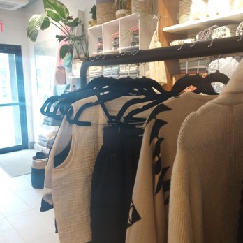 Cloudforest Coffee - Inside the Pokoloko store (which is co-located with Cloudforest Cafe) - Clothing on hangers is displayed on a rack inside a boutique store, with shelves of accessories and decor items in the background. - Coffee & Tea Near Me - Ottawa, Ontario