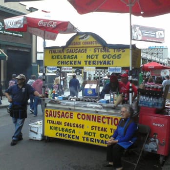Sausage Connection - a woman sitting in front of a food cart - Food Trucks Near Me - Boston, Massachusetts