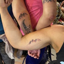 Matching mountain ridge tattoos.