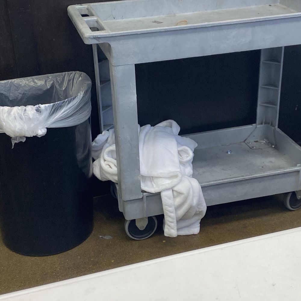 White robe tossed on dirty cart next to the trash by the manager.  Couldn't she hung it up?   No one else was in line.