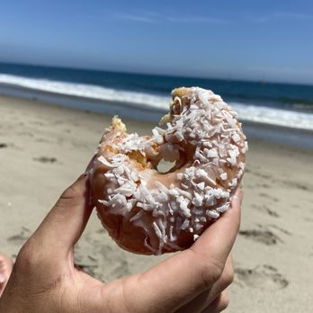 Eller's Donut House - a hand holding a donut on the beach - Donuts Near Me - Santa Barbara, California Eller's Donut House - a hand holding a donut on the beach - Donuts Near Me - Santa Barbara, California