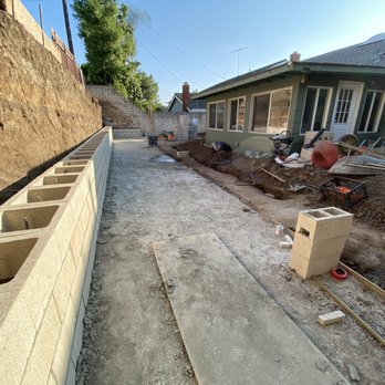 Sea Breeze Landscaping Construction - 8ft footing for retaining wall poured, and first 4 rows of 8 ft retaining wall in - Landscaping Near Me - Orange, California