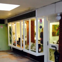 Karina's Gentlemen's Barbershop - A warm green glow coming from Karina's Barber Shop