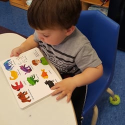 Creative Kids Childcare Center - Toddlers show early reading skills by reading independently