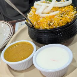 Lamb Biryani with Raita and a brown gravy.