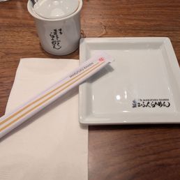 Marufuku branded plate, chopsticks and cayenne pepper powder pot artfully arranged.