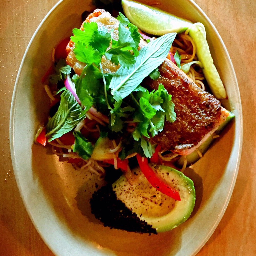 Delicious ocean trout with a slice of lemon and a bite of avocado.