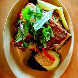 Delicious ocean trout with a slice of lemon and a bite of avocado.