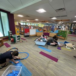 Sanibel Public Library - A group of kids and adults playing in a large area for young library users