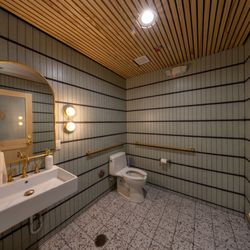 Beautiful Building Co. Construction + Design - Men's restroom - pine slat wood ceiling, arched brass mirror, mint green stacked wall tile with thick grout lines.